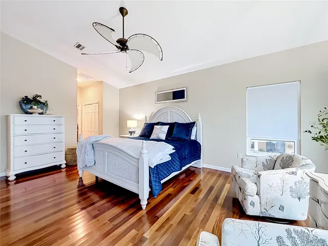 Step into a one-of-a-kind primary bedroom, adorned with high ceilings and stunning blue hues that mirror the beauty of the emerald waters just beyond.