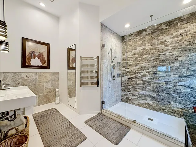 Indulge in luxury in this primary ensuite, featuring a custom rain shower that elevates your daily routine—an elegant retreat that embodies the essence of intercoastal living.