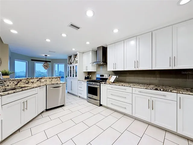 A chef's paradise, this beautifully bright kitchen showcases sleek white cabinetry and quartz countertops.