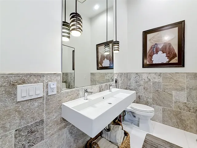 Step into modern elegance in this primary ensuite, where custom rain shower and sophisticated light fixtures harmonize to create a sleek sanctuary that defines contemporary luxury.