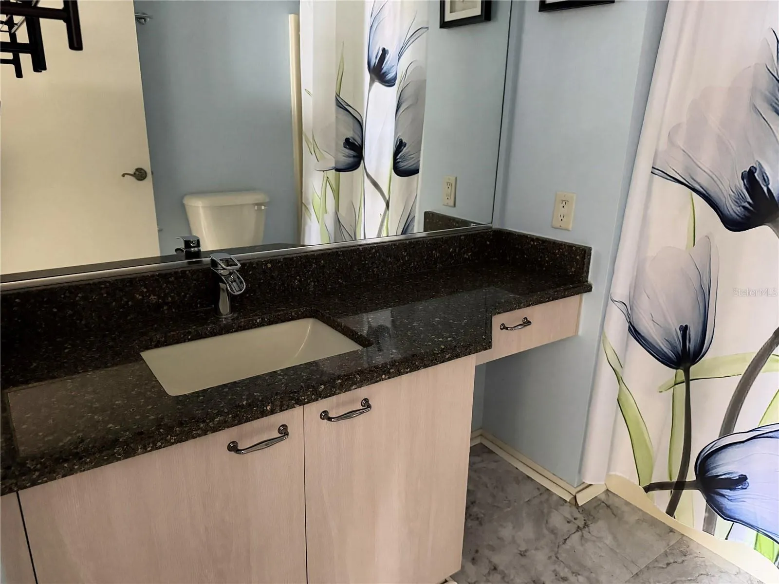 Guest bathroom with granite vanity countertop, integrated sink, and updated cabinetry.
