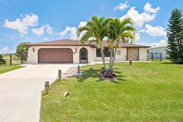 Tropical Curb Appeal with Oversized Two-Car Garage.