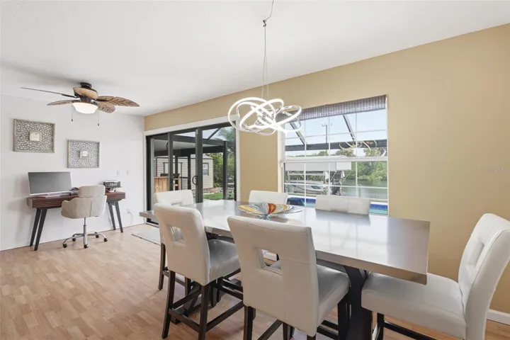 Dining Area Features Large Windows, Sliding Glass Doors that Frame Beautiful Views of Pool and Waterfront.