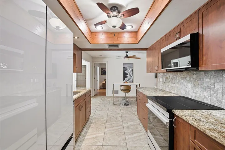 Kitchen Features Granite Countertops, Rich Wood Cabinetry, Decorative Tile Backsplash and Updated Appliances.