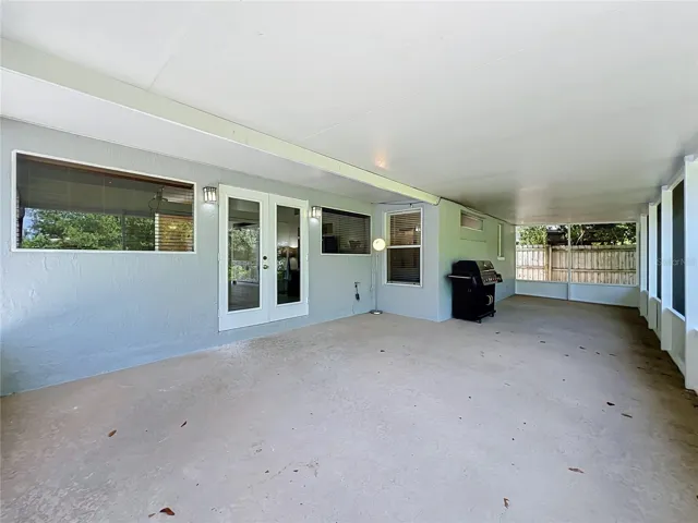 Large screened-in back porch perfect for relaxing and outdoor dining, featuring ceiling fans and views of the backyard.