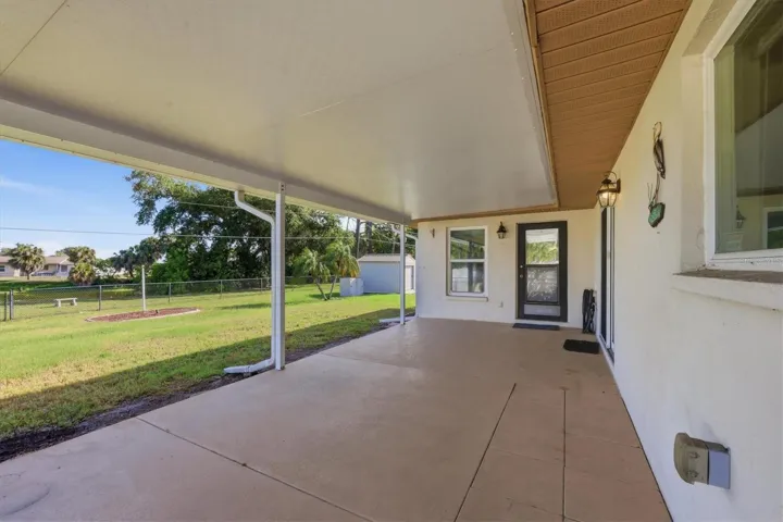 Covered rear patio has access to dining room and Florida room