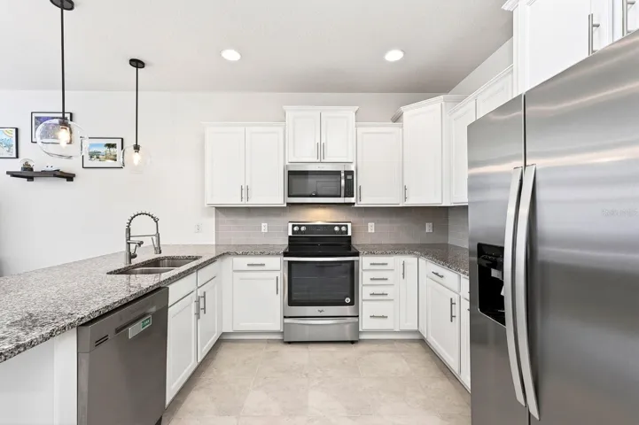 The kitchen delivers a fresh neutral color palette, stainless steel appliances, granite counters and upgraded fixtures.