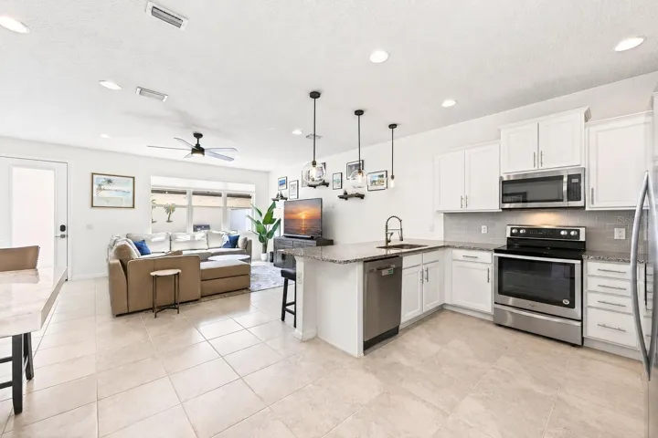The modern kitchen is open to the living and dining areas.