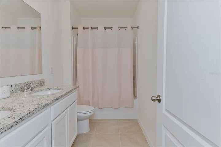 Additional full bathroom with granite countertops and modern finishes.