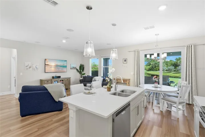 Beautiful and functional Kitchen with quartz countertops and shiny subway tile, pull out lower shelving on the lower cabinets, pull out trash/recyclable cans and a walk in pantry with abundant shelving.