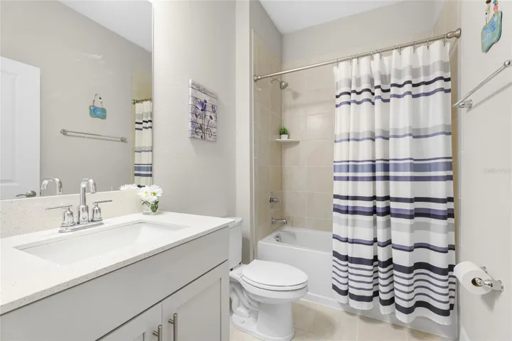 Second Bathroom with quartz top vanity and shower/tub combination.