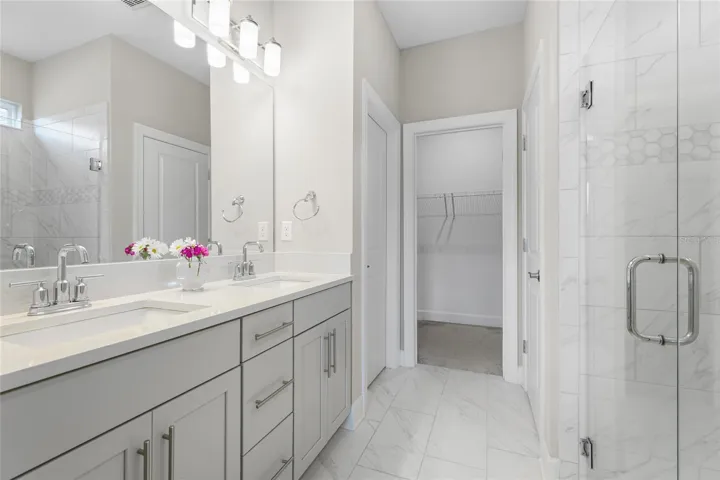 Owners ensuite bathroom with quartz countertops with dual sinks, large linen closet and grande owners walk-in closet. Spacious, large full glass, walk-in  shower with privacy window bringing in natural light.