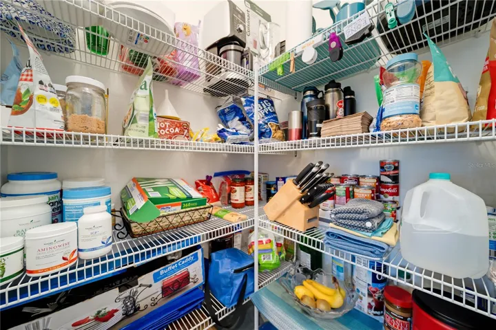 Walk-In Pantry with Exceptional StorageThe oversized walk-in pantry offers abundant shelving and organization space for groceries, appliances, and household essentials. Buyers searching for functional Florida homes will appreciate the extra storage and convenience this pantry provides for everyday living and entertaining.