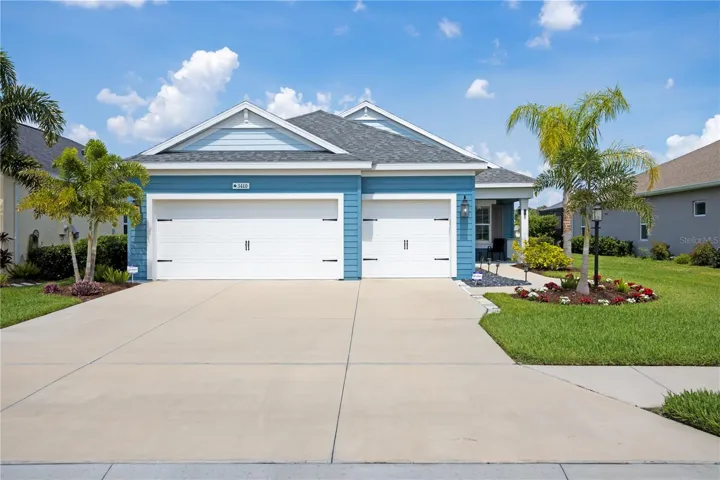 Beautiful coastal-inspired exterior with tropical landscaping and oversized 3-car garage in Silverleaf Parrish Florida.