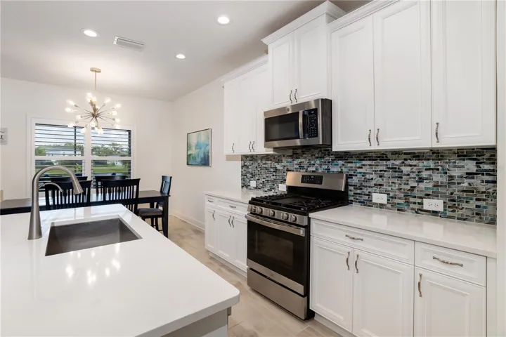 Open Kitchen Layout with Water Views & Seamless Living IntegrationFunctional and elegant kitchen design offering clear sightlines into the dining and living areas while maximizing natural light and lake views. Perfect for Florida buyers seeking an open-concept lifestyle home.
