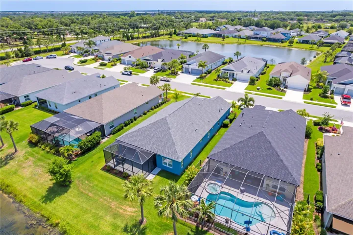 Aerial Front Elevation & Community ViewPerfectly positioned within a well-maintained community, this home offers attractive curb appeal, manicured landscaping, and a desirable location near the community lake.