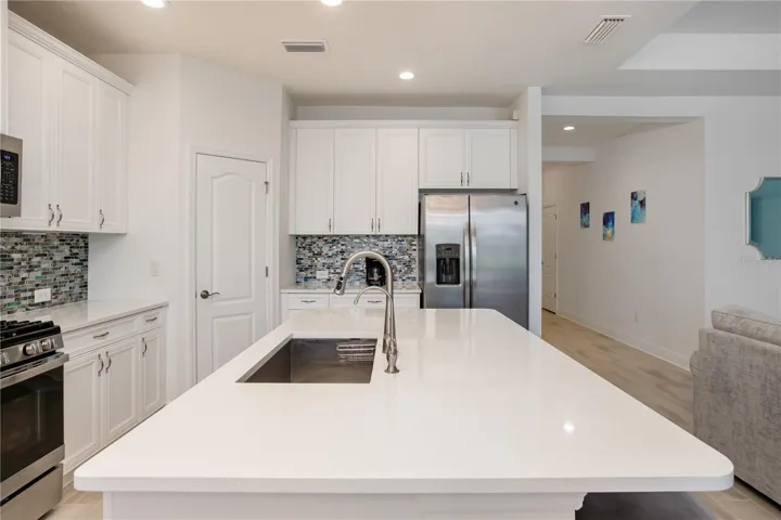 Large Quartz Island Perfect for Entertaining & Everyday LivingOversized center island with seating, undermount sink, and abundant prep space anchors this stunning open kitchen. Ideal for entertaining, casual dining, and gathering with family in this move-in-ready Florida home.
