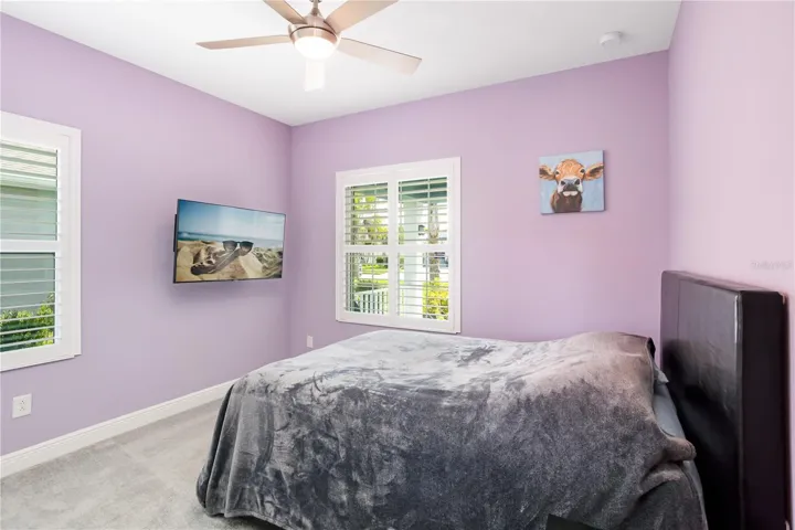 Guest Bedroom with Soft Coastal Colors & Plantation ShuttersBeautiful guest room featuring calming tones, natural light, and ample closet space. Perfect for visiting family, seasonal residents, or buyers looking for flexible space in a Florida lifestyle home.