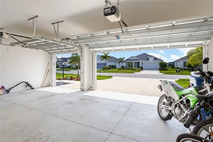 Oversized 3-Car Garage with Epoxy-Ready Space for Golf Carts, Toys & StorageBright and spacious 3-car garage with high ceilings, automatic openers, and extra room for motorcycles, golf carts, kayaks, or workshop space. Perfect for buyers relocating to Florida who want practical storage and clean curb appeal in a newer luxury home community near Sarasota, Lakewood Ranch, and Bradenton.