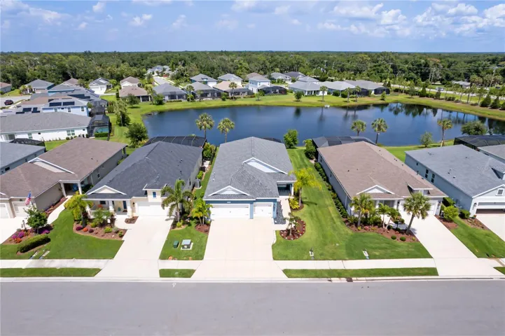 Lake View and Neighborhood PerspectiveThis elevated aerial perspective showcases the tranquil community lake, surrounding executive homes, and beautifully maintained streetscape. The property’s location offers a balance of privacy, scenic surroundings, and convenient access to Florida Gulf Coast amenities.