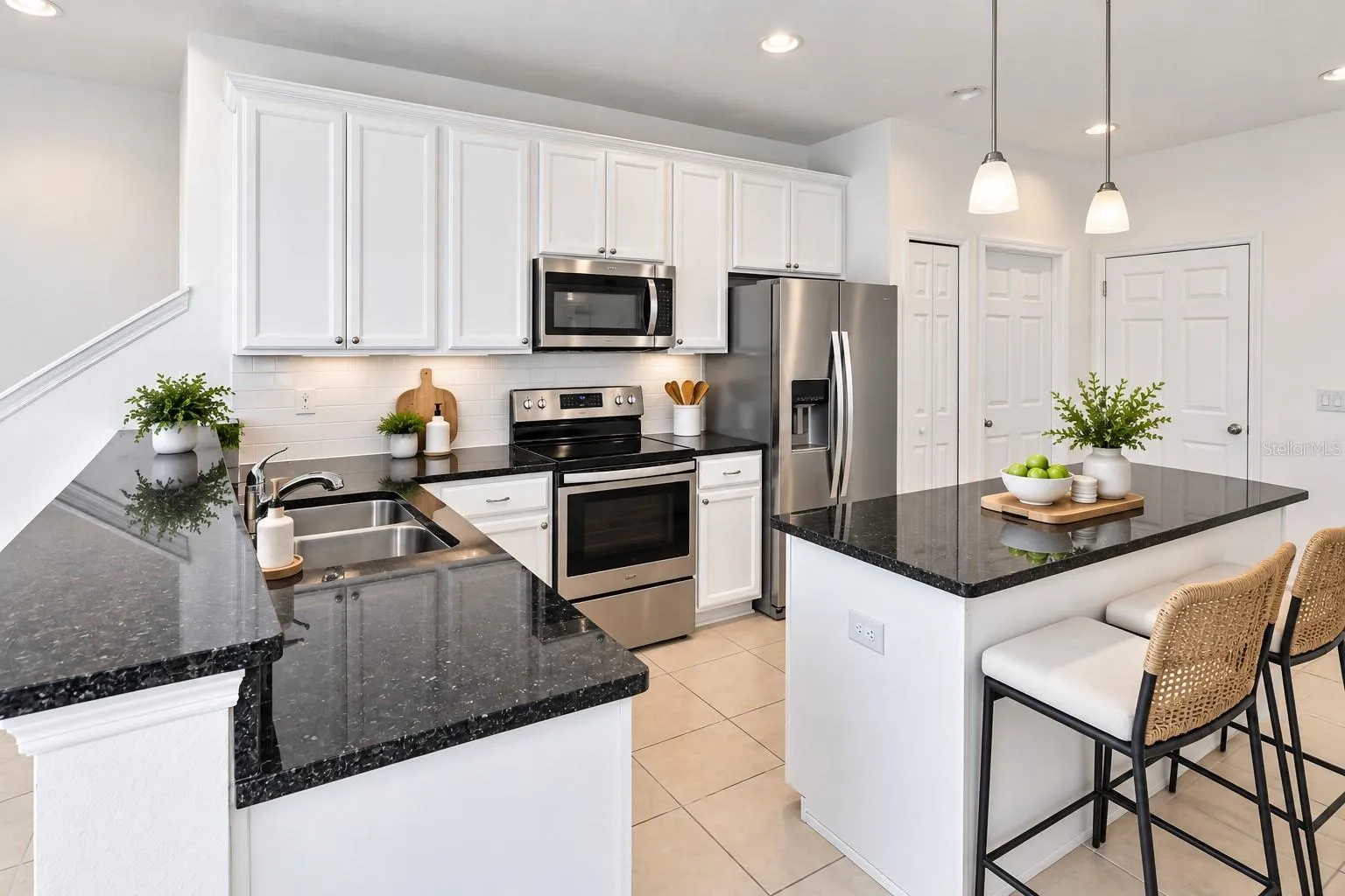 Another view of the spacious kitchen featuring abundant cabinet and counter space, stainless steel appliances and center island.