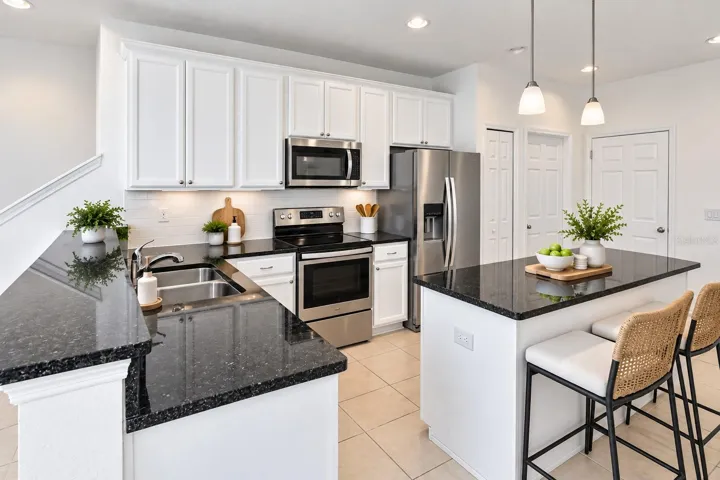 Another view of the spacious kitchen featuring abundant cabinet and counter space, stainless steel appliances and center island.