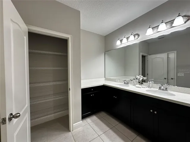 Master bathroom with double sink and linen closet.