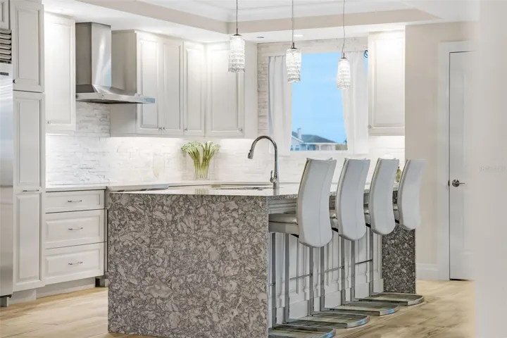 This shot shows you the natural light that the kitchen gets along with the under counter lighting.  Notice the waterfall finish for the center island that is reflected on both sides of the breakfast bar.