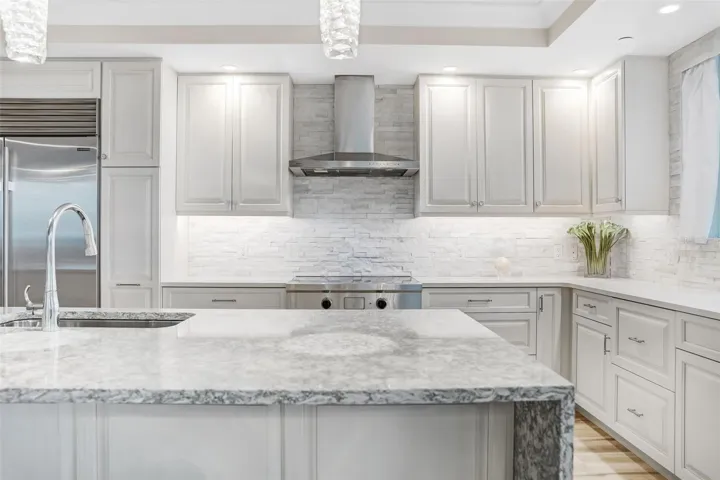 This is a closer look at the hand picked light fixtures for the kitchen island and beautiful backsplash and Wolf range & hood.