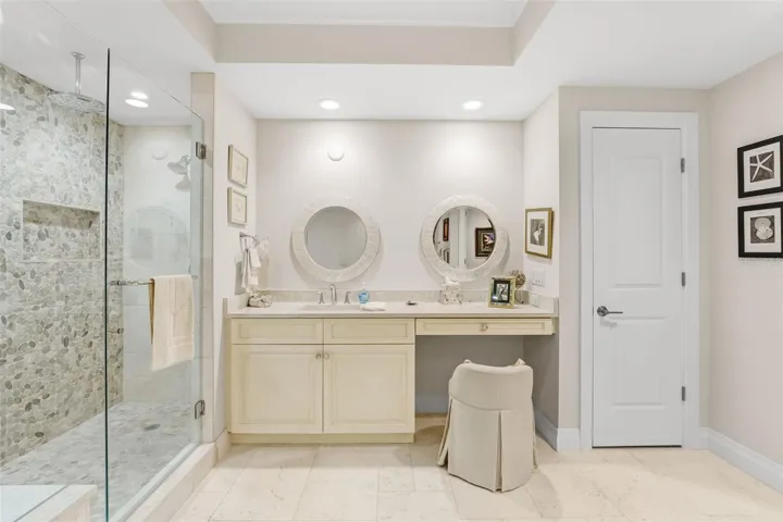 Separate vanities in the primary bathroom plus makeup area with a linen closet.