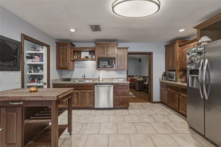 Kitchen has granite countertops, wood cabinets and stainless steel appliances.  Pantry can be seen in the picture.