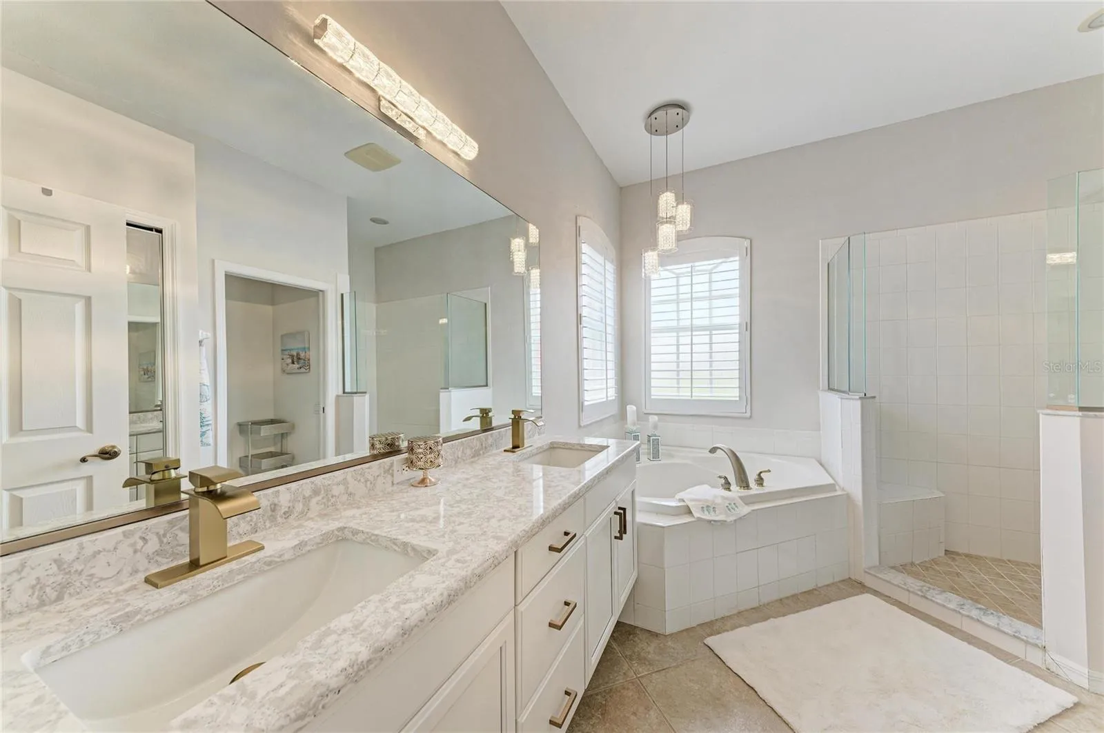 Primary en suite features stone finishes, dual sinks