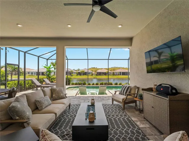 Expansive outdoor space with lake view, outdoor kitchen/bar and pool.