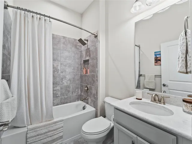 The beautifully appointed main bathroom features a shower/tub combination with a clean timeless design.
