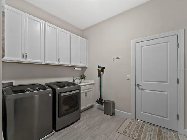 Spacious laundry room with cabinets and sink.