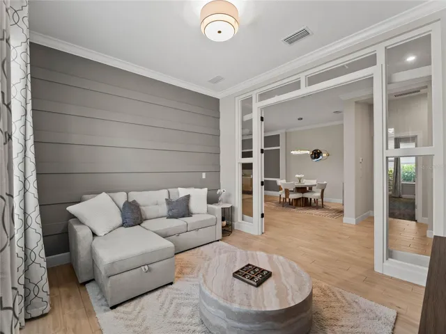 A comfortable den with elegant enclosed glass doors, providing a quiet and versatile space for a home office, media room, or private retreat.