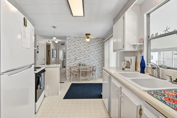 Kitchen area facing back of home with a eat in table to the side.
