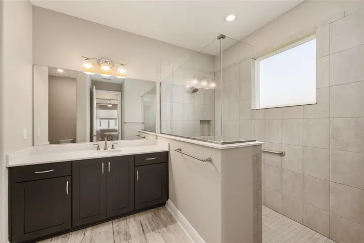 Second primary ensuite with a large zero-entry walk-in shower, spacious vanity, and neutral finishes.