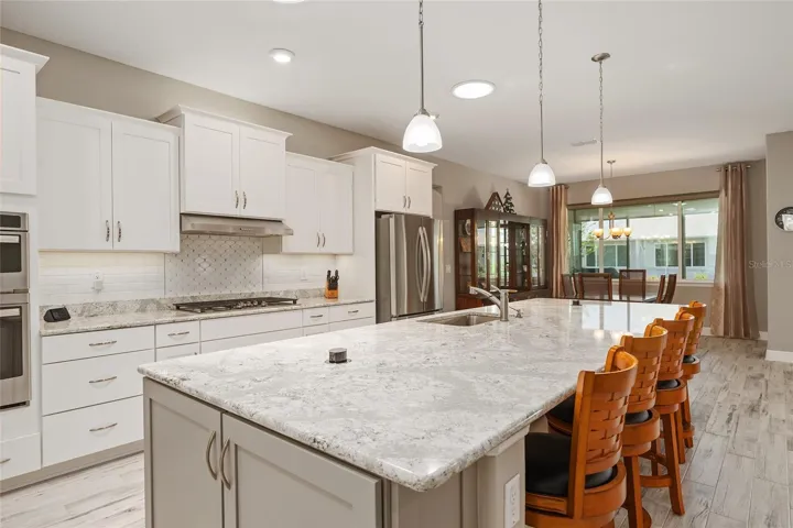 Cambria Quartz kitchen island with two disappearing pop-up outlets, built-in soap dispenser, and end cabinets for extra storage and convenience.