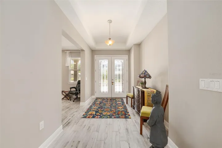 Beautiful lead glass double-door entry and foyer with tray ceiling, leading to a versatile flex space ideal for an office or sitting room.