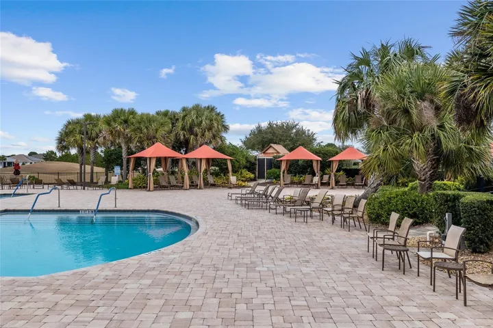 Candler Hills resort-style pool featuring swim lap lanes, beach entry, spacious pool deck, and clubhouse views—perfect for exercise, relaxation, and enjoying the Florida lifestyle.
