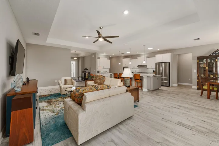 Open floor plan perfect for entertaining, featuring neutral finishes, ceramic plank flooring, tray ceilings, upgraded hardware, dovetailed drawers, ceiling fans with lighting, and a warm, move-in-ready feel.
