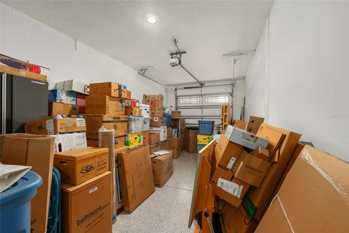 Deep third-car garage featuring epoxy flooring and recessed lighting, offering excellent space for a truck, SUV, golf cart, or added storage.