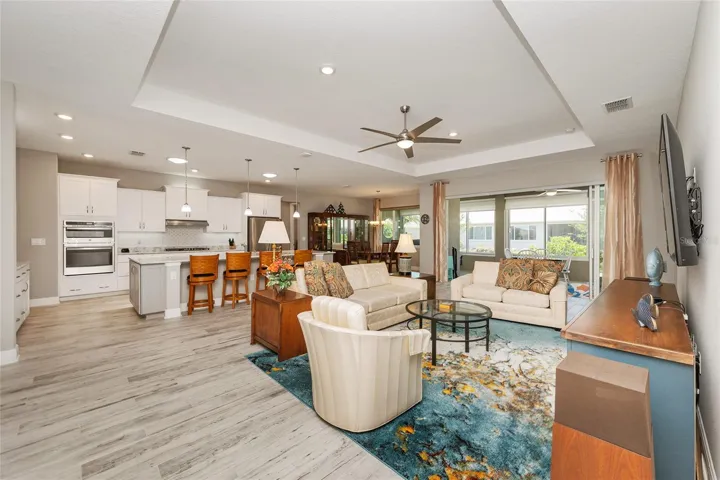 Another view of the open floor plan with stacking sliding doors opening to the enclosed lanai, creating a seamless flow for everyday living and entertaining.