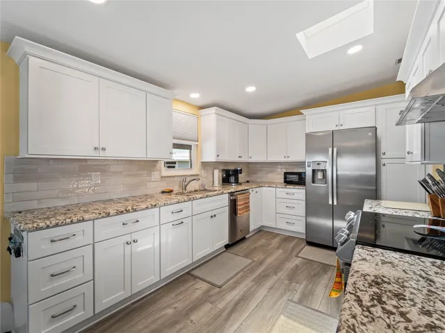Kitchen w/ granite counters, wood cabinets & stainless appliances