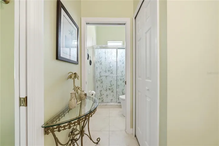 walk in tile shower with commode.  Packet door for privacy.  Linen closet keeping everything at finger tips