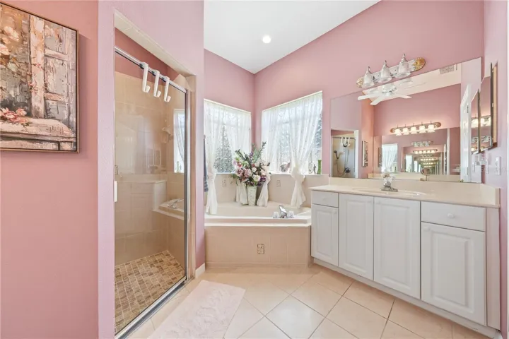 Hugh tile walk in shower, soaking tub, his sink