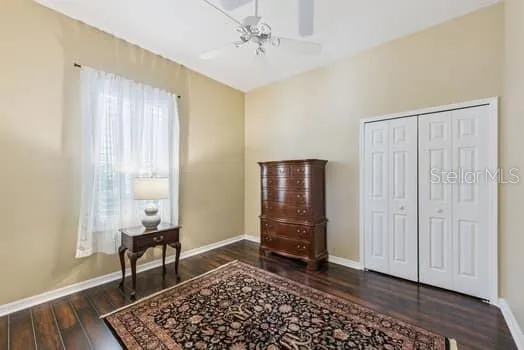 3rd bedroom with engineered hardwood flooring, double door closet and ceiling fan.