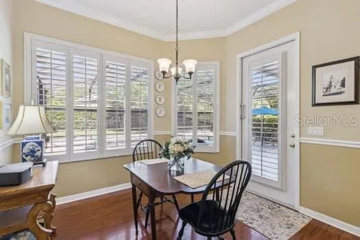 Large eat-in kitchen with plantation shutters, crown molding, and door leading to lovely screen enclosed patio and pool