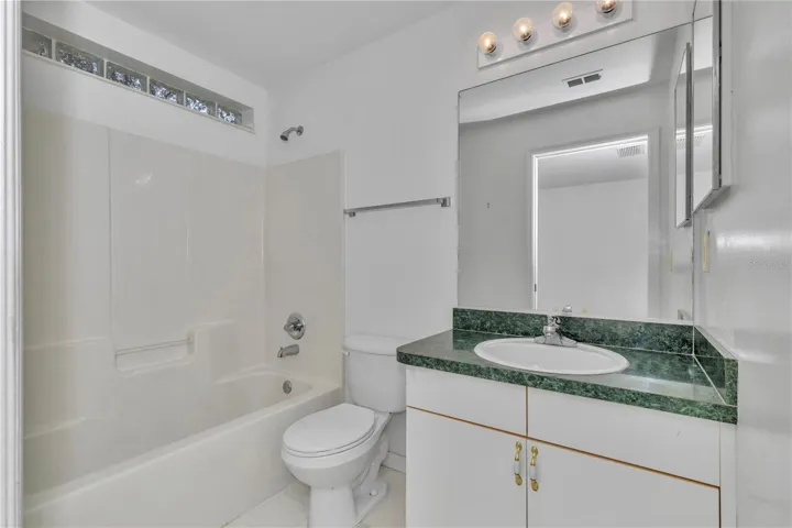GUEST ENSUITE BATHROOM WITH VANITY AND TUB